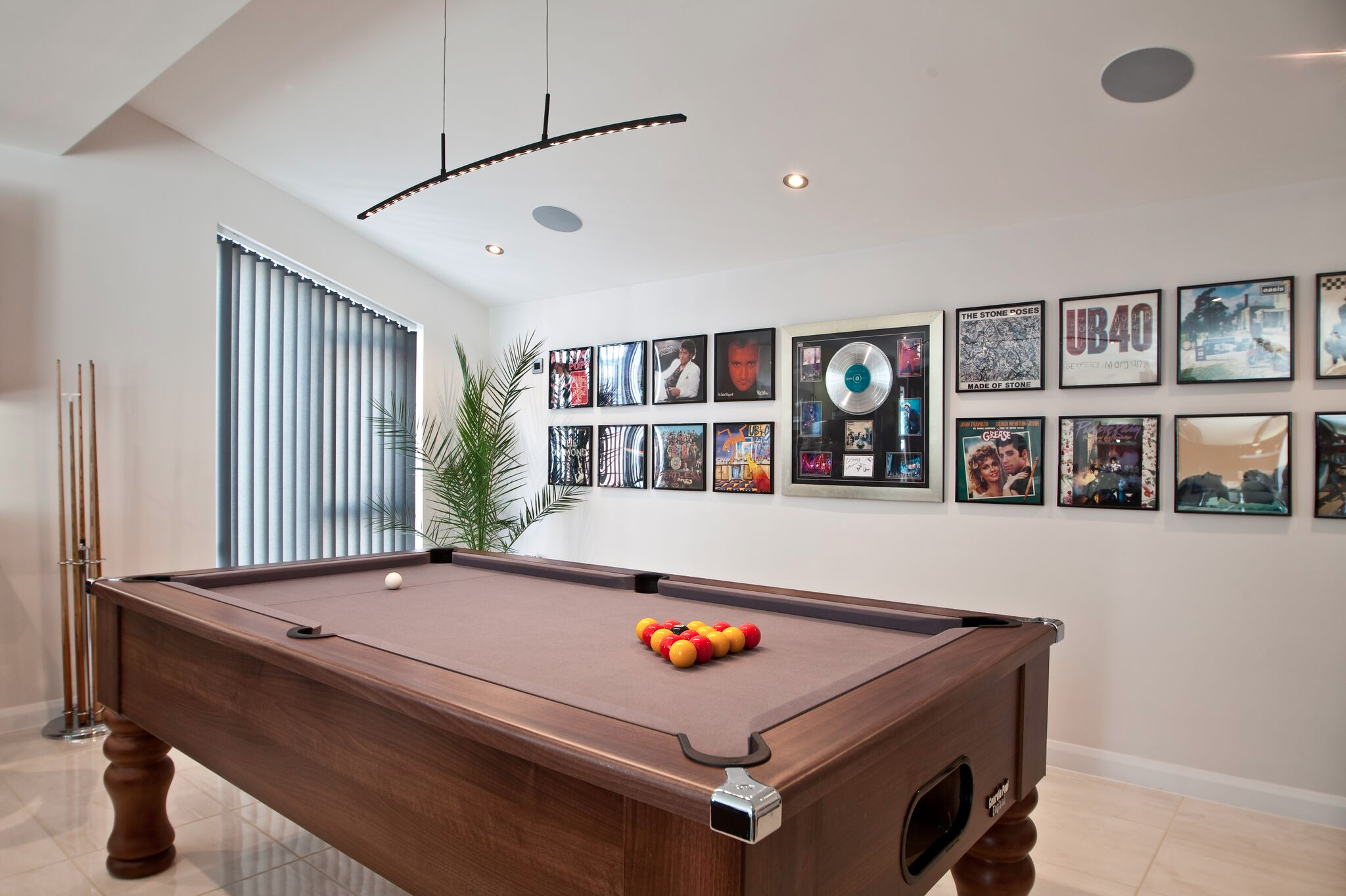 Snooker table with vinyl records framed on the wall